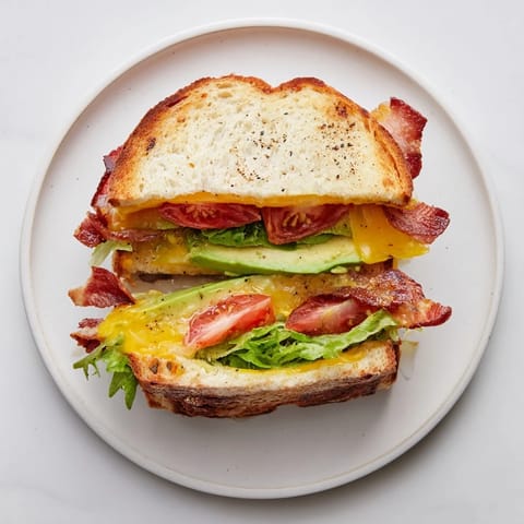 Thick-cut bacon and creamy avocado fill this Avocado BLT Grilled Cheese, with melted cheddar oozing between toasted bread halves.