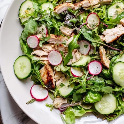 Close-up of Spring Detox Chicken Salad featuring tender grilled chicken, sliced avocado, and fresh spring vegetables on a bed of greens.