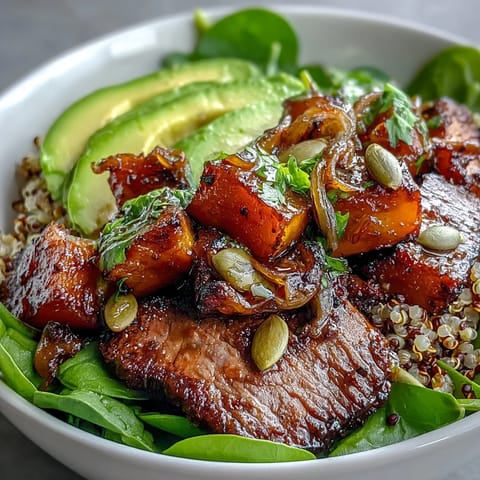 Golden roasted butternut squash steak bowl with fluffy quinoa, greens, and creamy avocado.