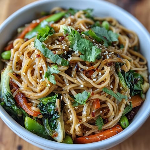 Freshly cooked shirataki noodles toss with crisp bok choy, bell peppers, and a savory ginger sauce in a warm bowl.  