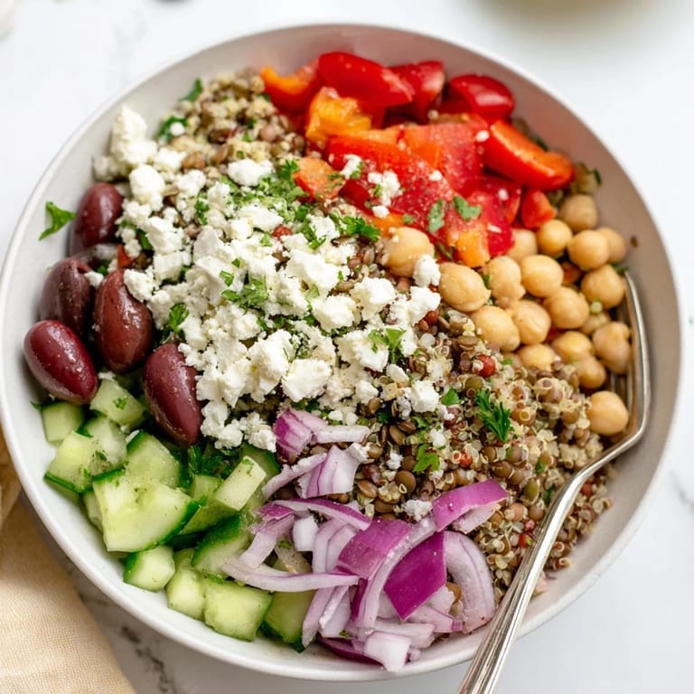 Close-up of a vibrant Greek Power Salad, featuring Kalamata olives, diced red onion, and fresh parsley, drizzled with a zesty Greek vinaigrette.